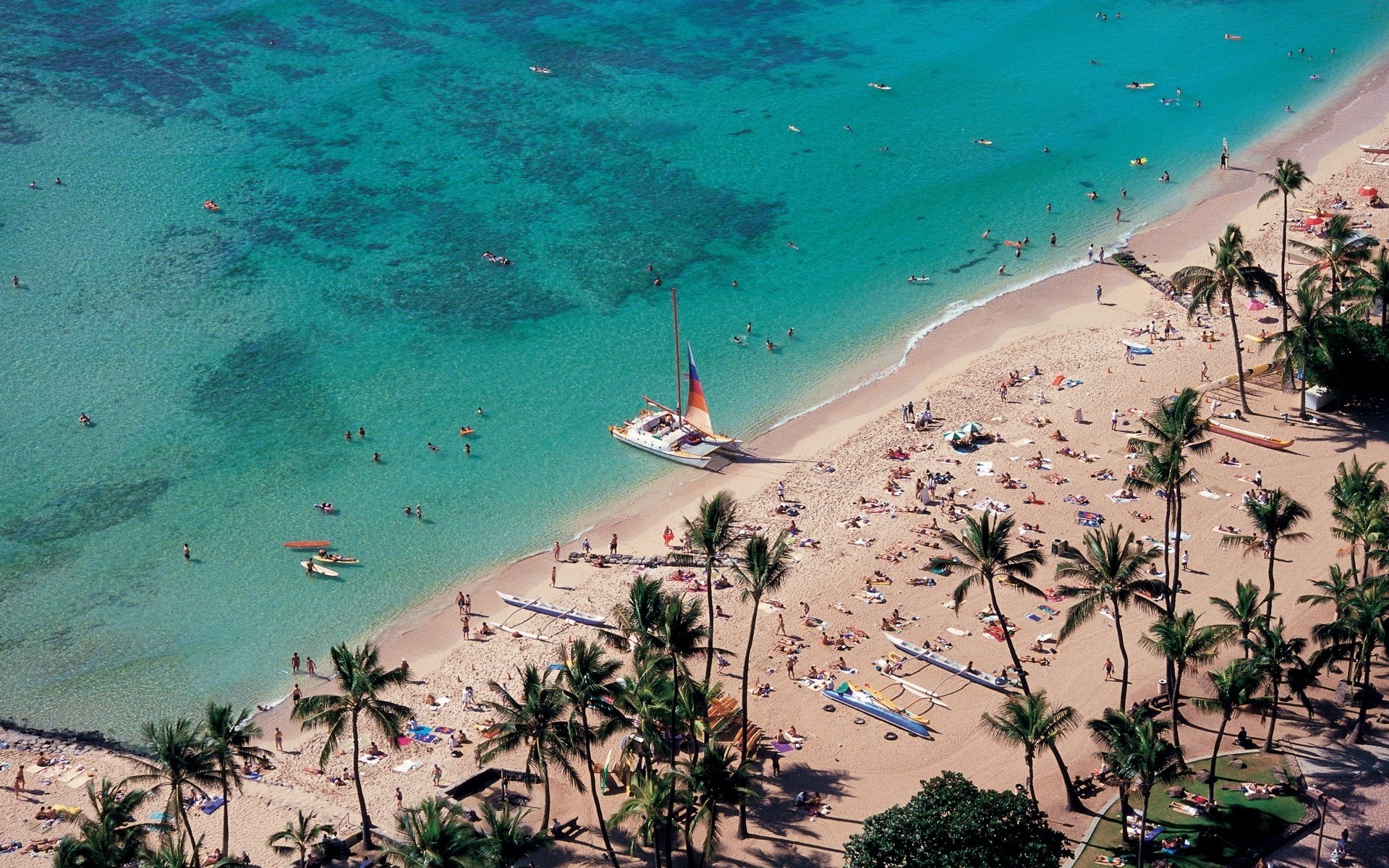 strand sand leichte wellen wasser palmen menschen segelboot höhe landschaft natur urlauber sonnenbrand sommer hitze hitze