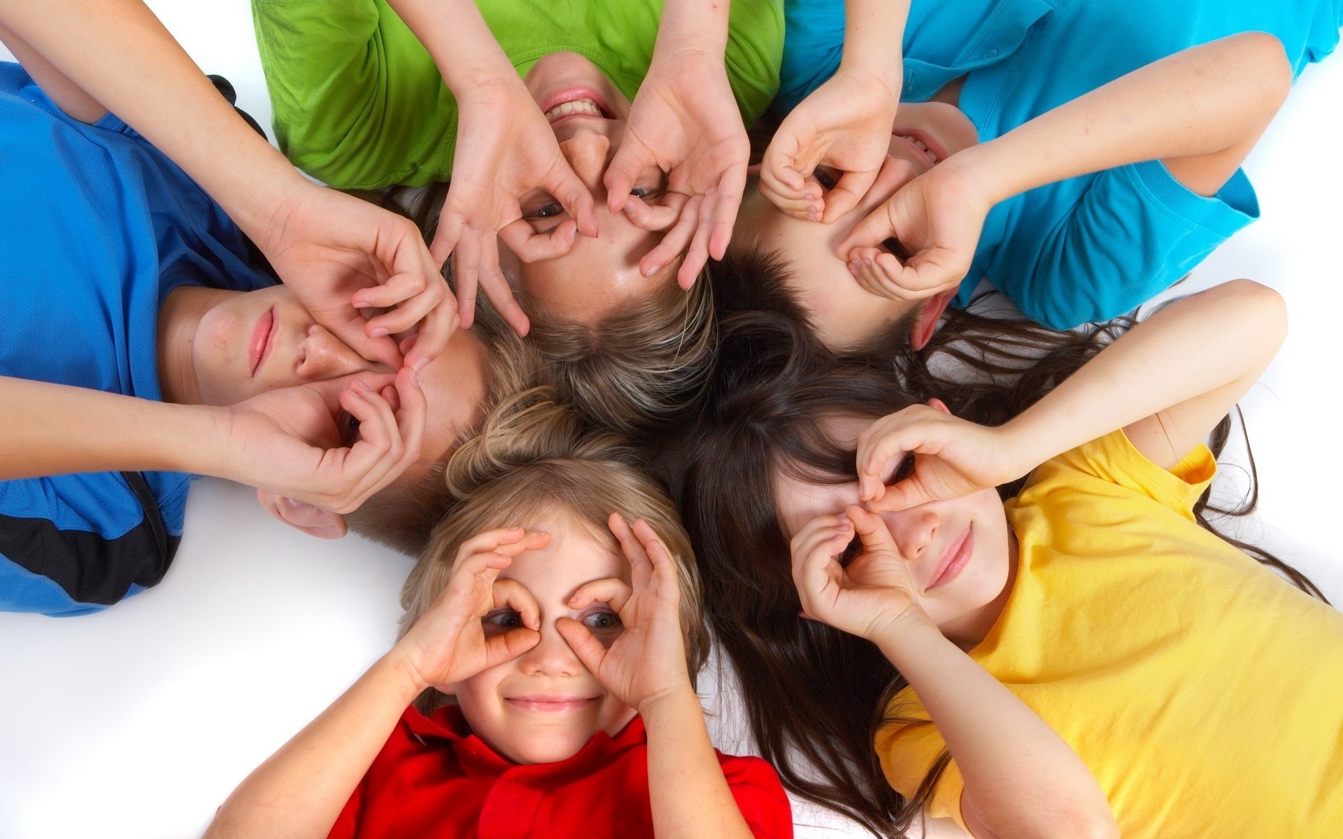 a handful of on the face children colorful t-shirt look mood joy emotions hands palm circle eyes five