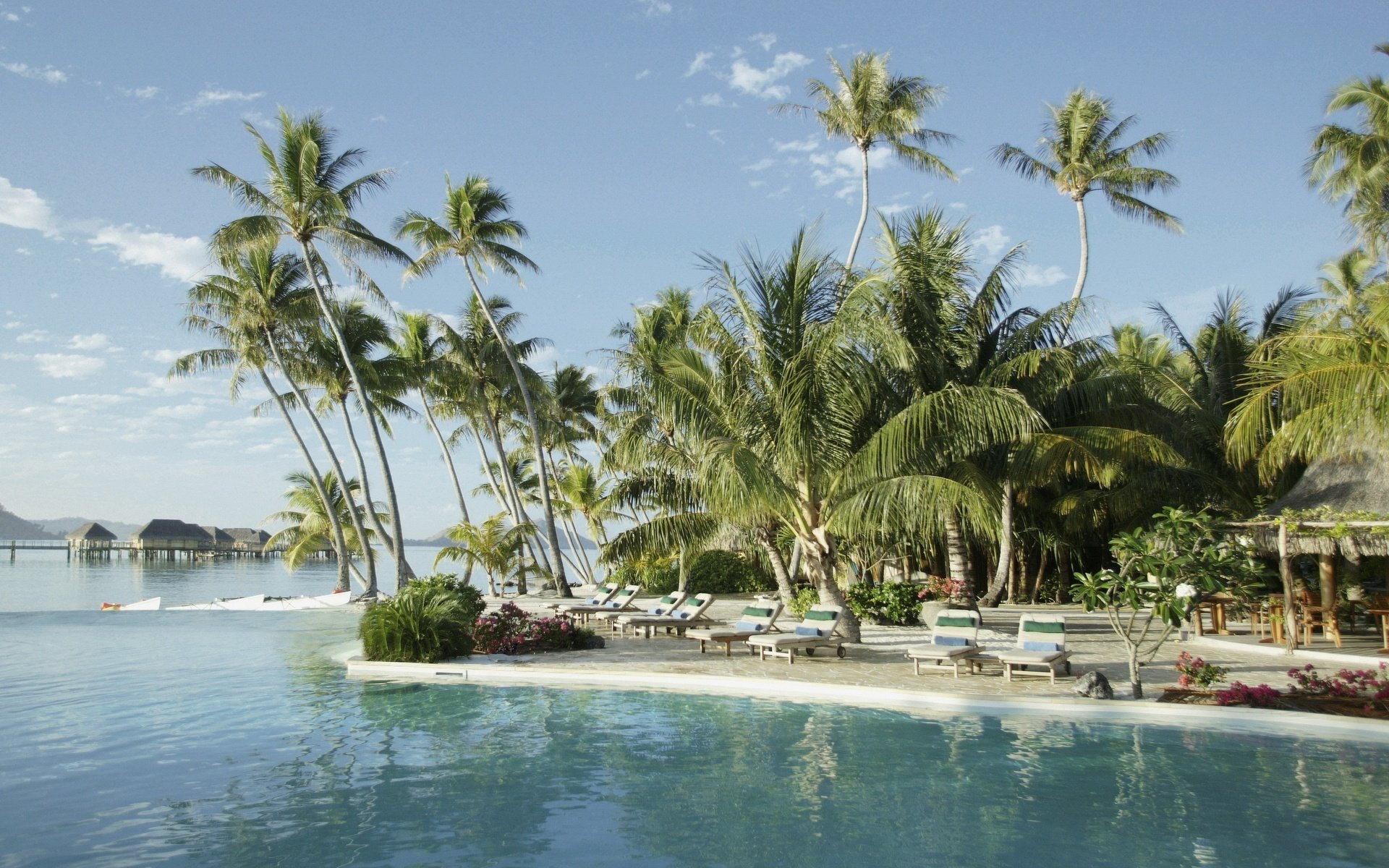 häuser palmen sonnenliegen meer strand wasser himmel resort