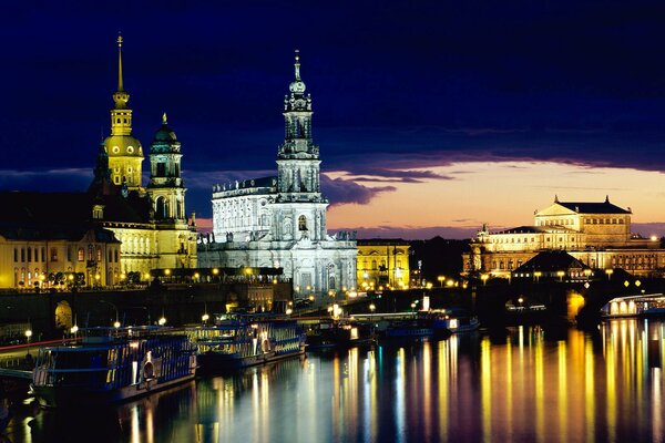 Las torres y las luces de la ciudad se reflejan en el agua de la noche