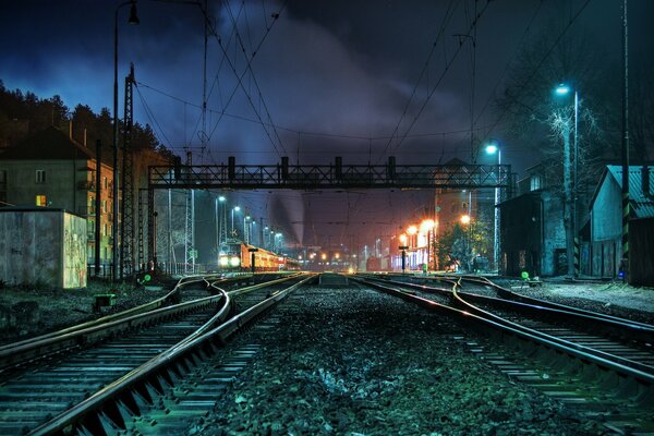 Railway at night between small houses