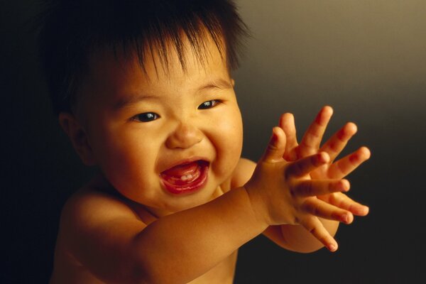 A small child claps his hands