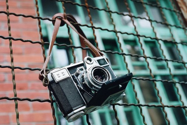 The camera is hanging on an iron fence