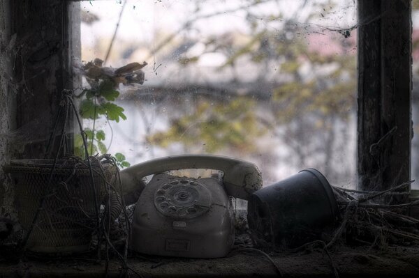Post-apocalypse. A disk phone and flowers on the windowsill