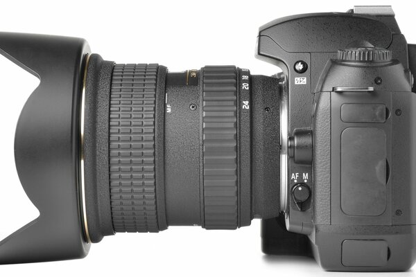 Fotocamera professionale con obiettivo a fuoco lungo su sfondo bianco
