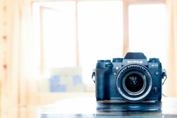 A camera with a large lens in the room on the table