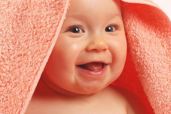 Happy baby after bathing with toys