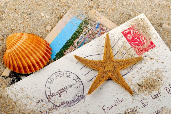 Envelopes on the sandy shore with shells