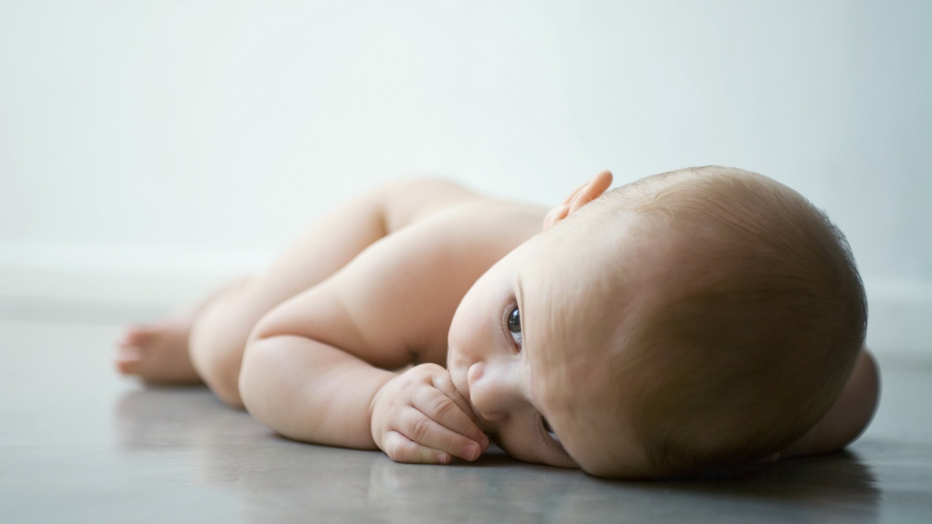 ein trauriger kleiner mann liegt auf dem boden nackt blick kind baby krümel liegt