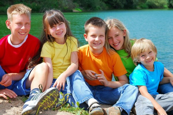 Bambini amichevoli vicino all acqua in una giornata di sole. Cinque sorrisi