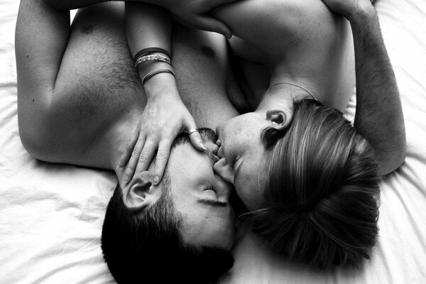Sur le lit, un homme et une femme s embrassent