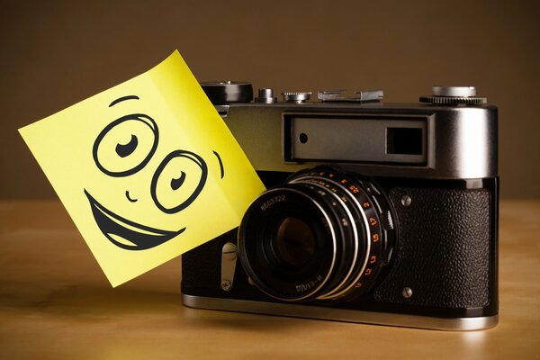 A camera with a smiling smiley face on the table