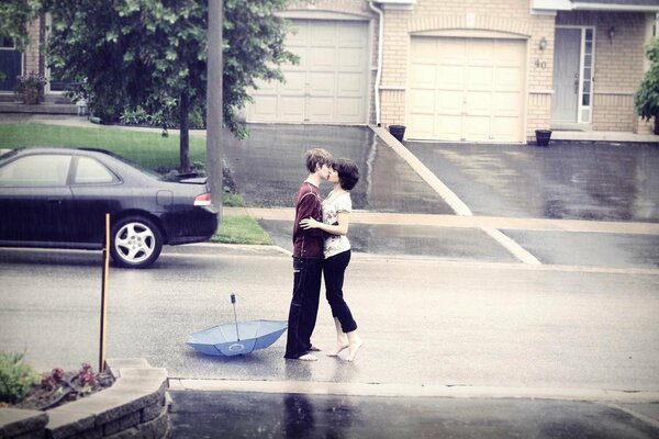 Девушка и парень нежно целуются под дождем