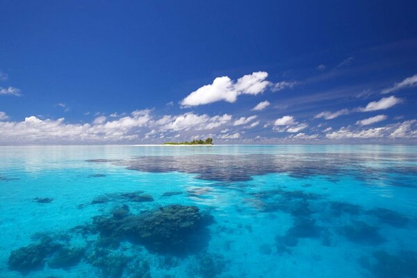 La mer bleue, quelque part au loin, une île verte est visible