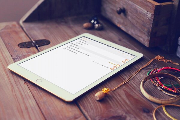 A white tablet on a wooden table