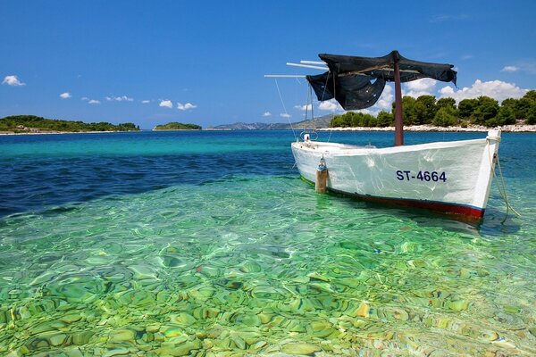 Boat on the seashore with crystal clear water