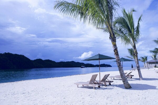 Liegestuhl am weißen Strand in einer tropischen Insel
