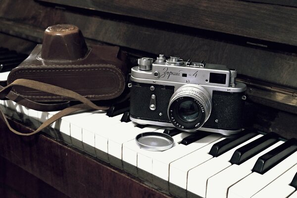 The camera and the case are on the piano keyboard