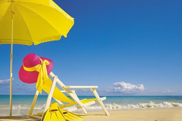 Chaise longue with umbrella on the white beach