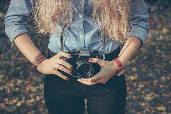 Девушка с ретро-фотоаппаратом Zenit в руках