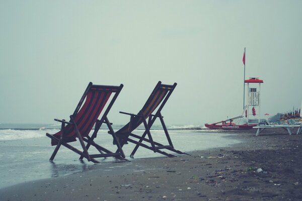 Leżaki na szarej, pochmurnej plaży