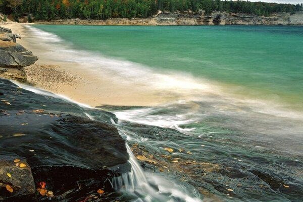 Spiaggia meravigliosa, pietre, piccola cascata