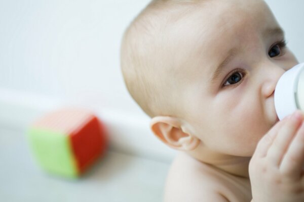 Baby trinkt Milch aus einer Flasche