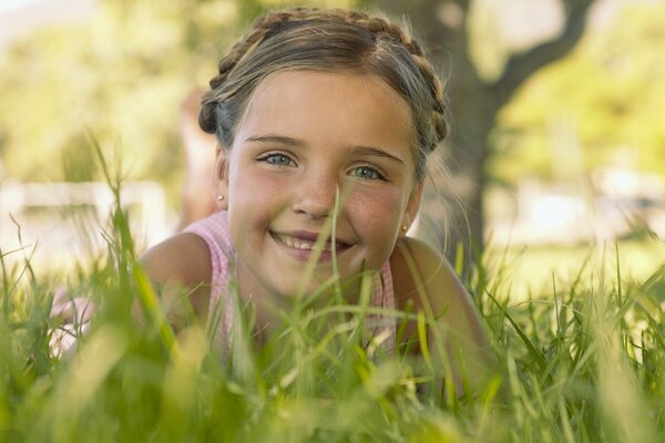 Dziewczyna z uroczym uśmiechem leży w trawie