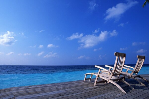 The blue expanse of the sea. A couple of sunbeds on the pier