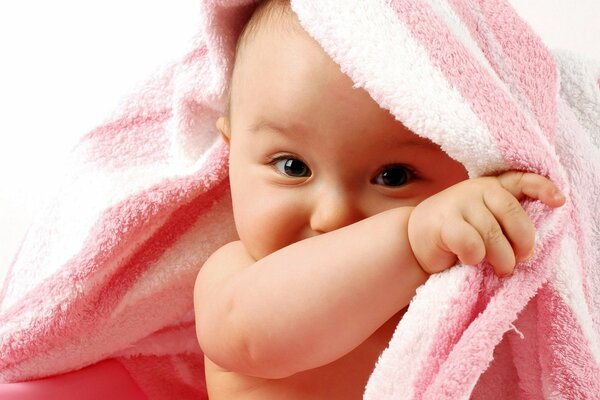 Shy child hiding behind a towel