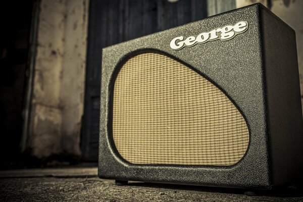 An old guitar speaker on the background of a concrete wall