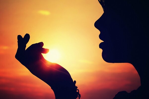 A woman holds the sun in her hand