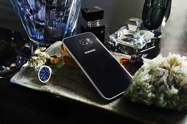 Samsung phone with amber and crystals on the table
