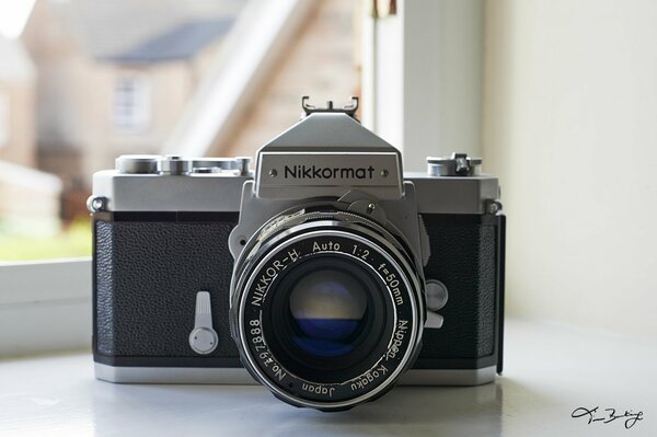 The retro camera is lying on the windowsill