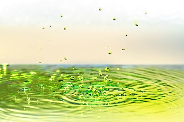 Green drops fall from yellow water