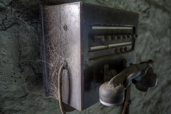 An old phone covered in cobwebs