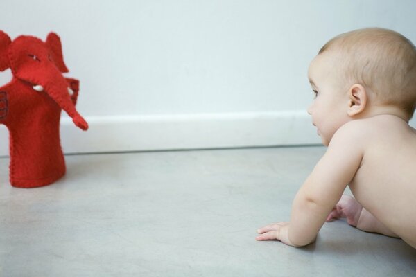 A child studies a red toy