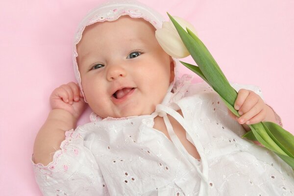 Entzückendes Baby mit weißer Tulpe