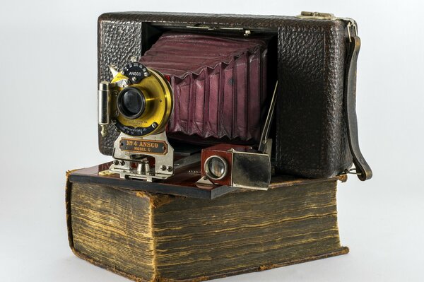 An old camera is lying on a book