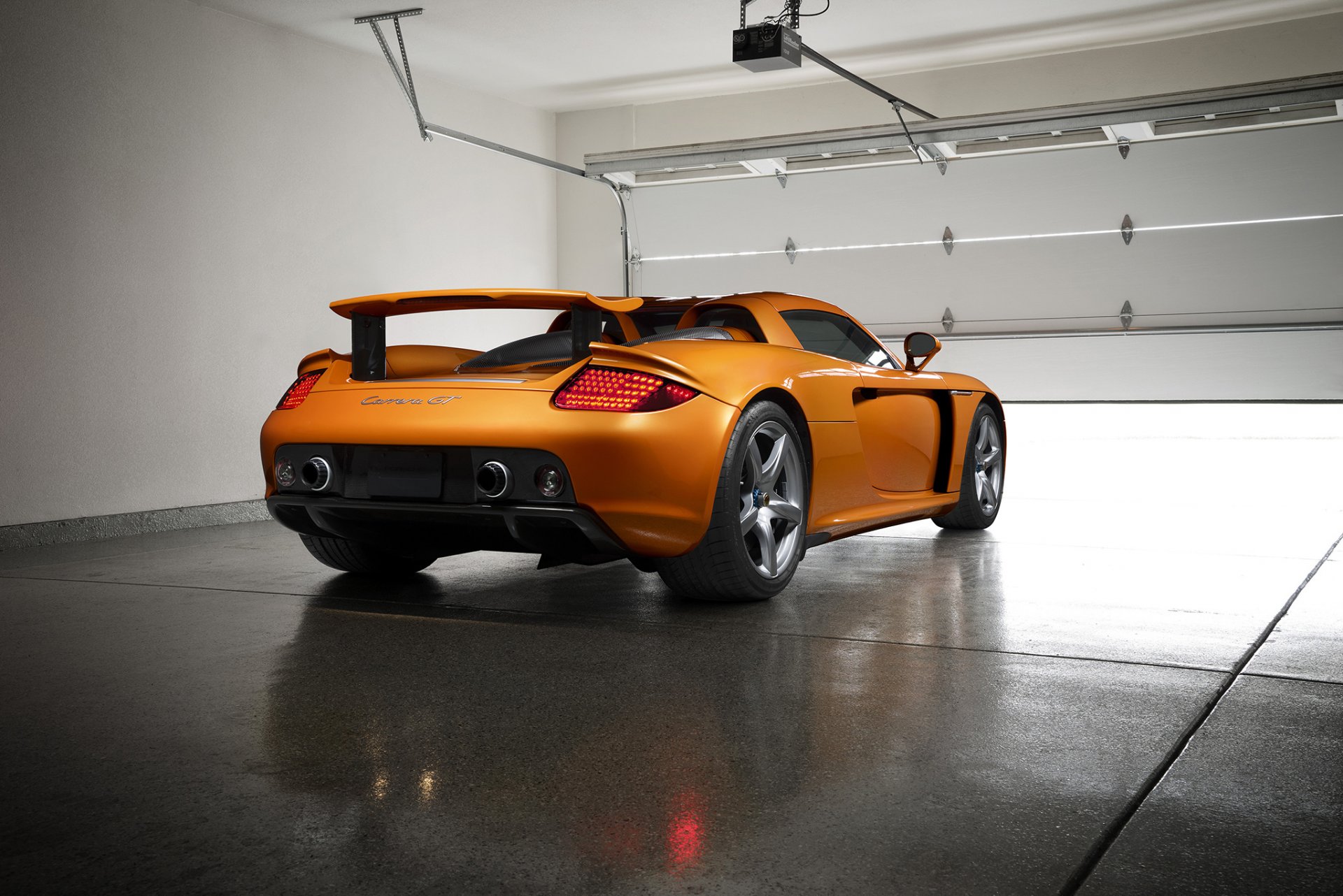 porsche carrera gt orange borealis exotique supercar lumière nigth arrière garage