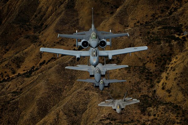 Истребители f- 16, f -22, f -15 в небе над холмами