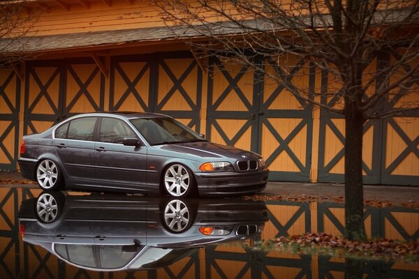 BMW gris avec réflexion dans la flaque d eau