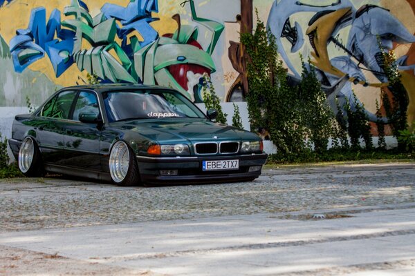 Dark classic BMW e38 on graffiti background