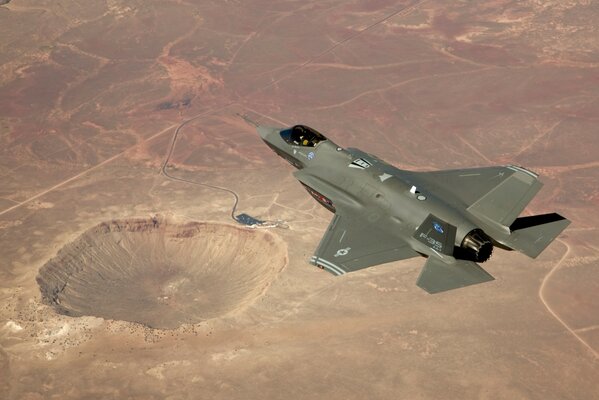 An American fighter jet is flying over the desert