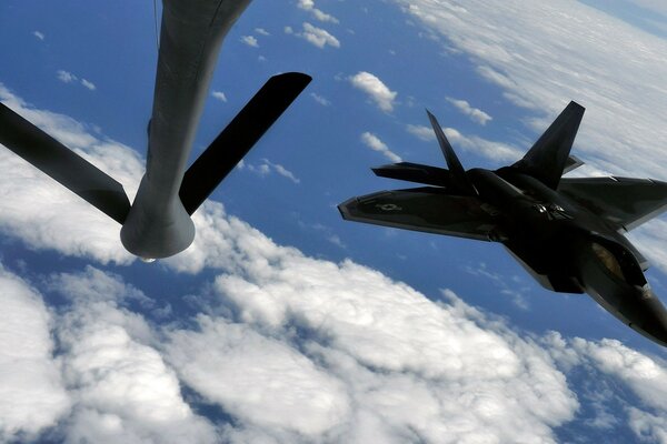 F-22 military fighters refueling over the skies