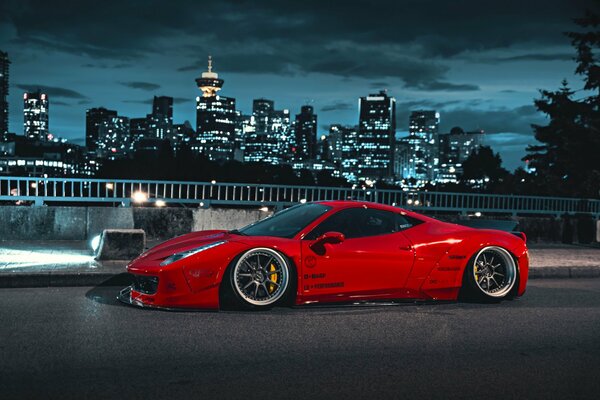 Red Ferrari on the background of the lights of the night city