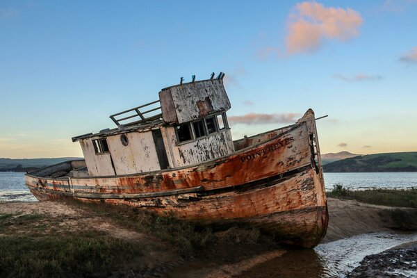An ancient ship stands on the shore in California