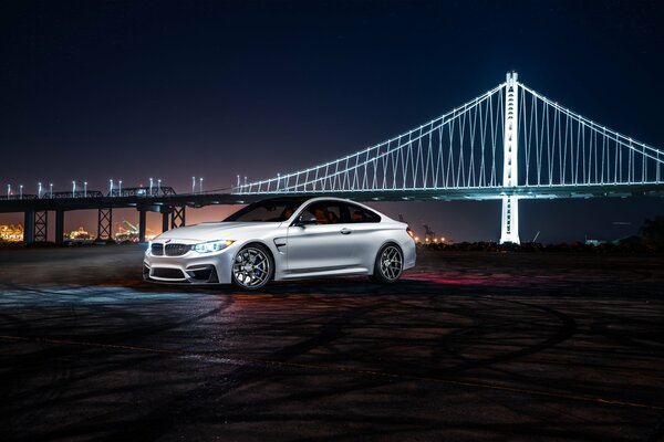 BMW blanco en la noche contra el puente blanco