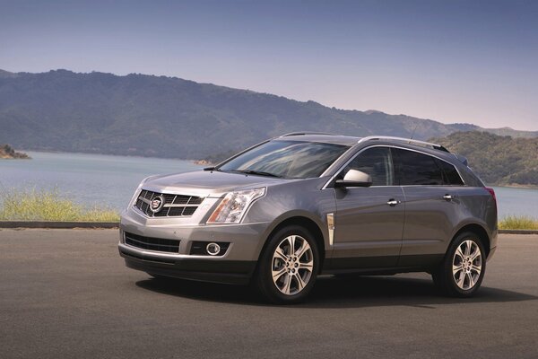 Cadillac srx SUV grau im Hintergrund der Berge