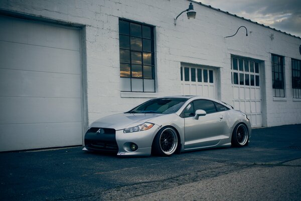 A chic gray Mitsubishi stands near the garages